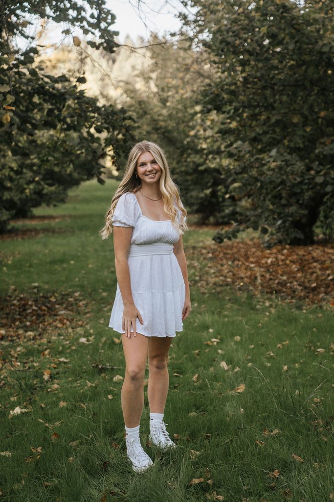 senior standing in an orchard at dorris ranch in springfield oregon