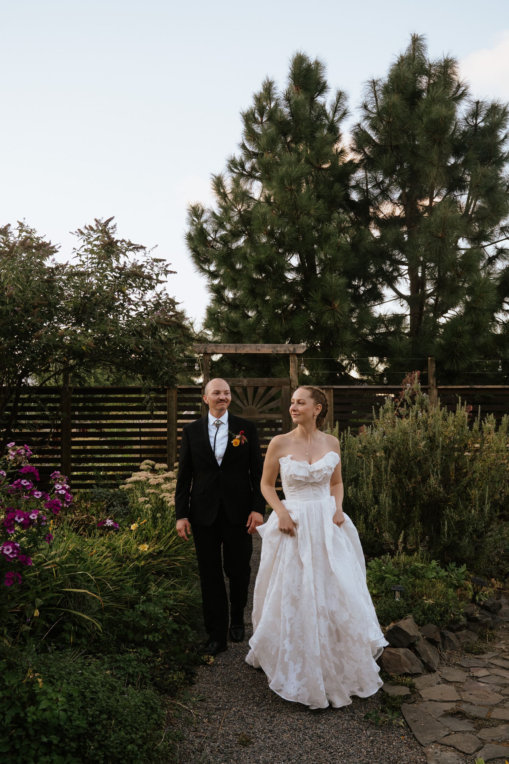 couple walking through gardens at long table farm in eugene